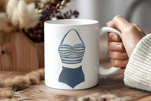 a person holding a coffee mug with a picture of a bra on it