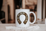 a white coffee mug with a horseshoe on it