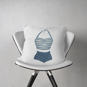 a white chair with a blue and white pillow on it