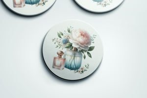 three coasters with flowers and perfume bottles painted on them