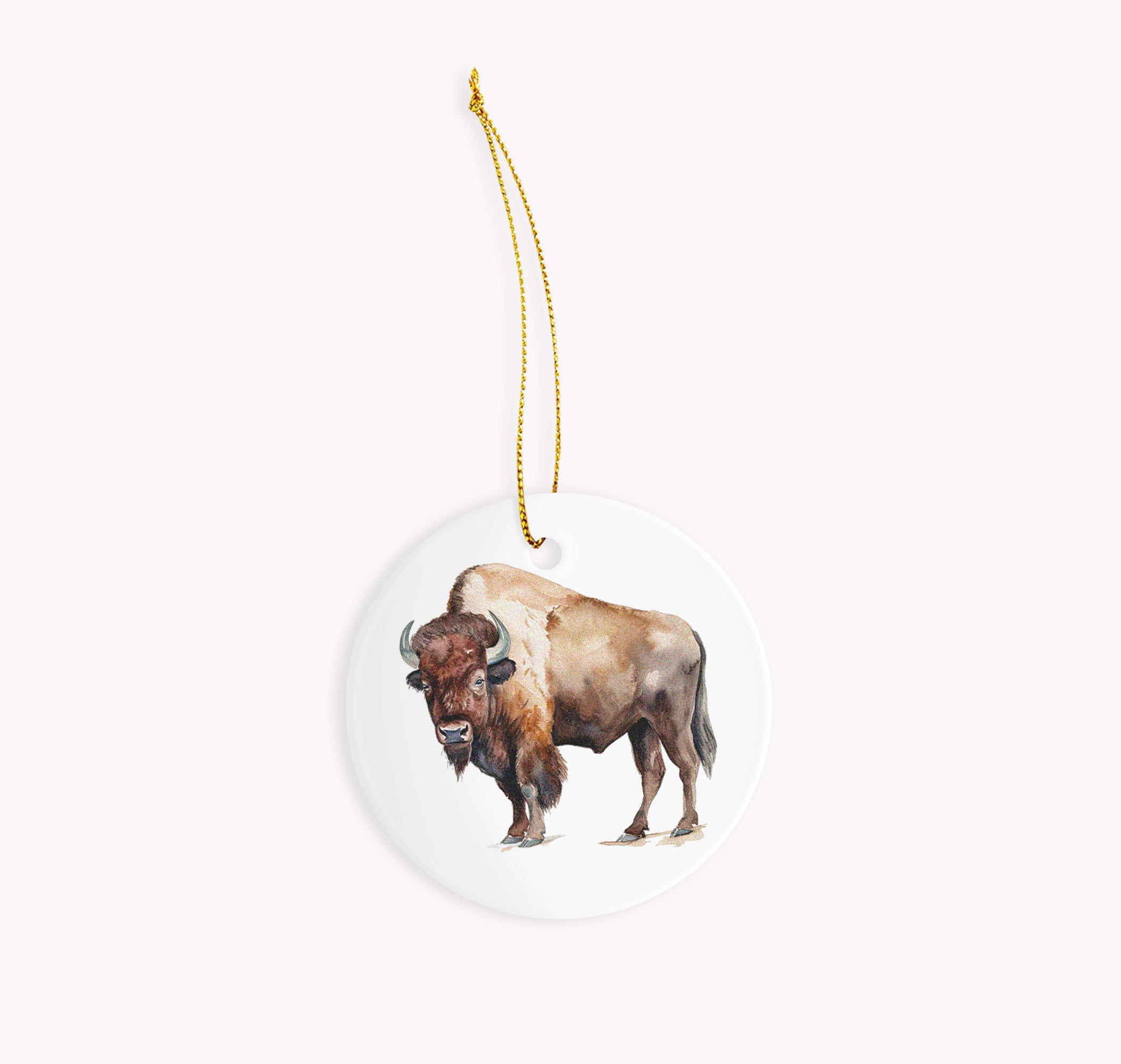 a buffalo ornament hanging from a gold chain