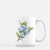 a white coffee mug with blueberries on it