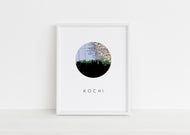A framed illustration of a map of Kochi, India, with a silhouette of a city skyline in the center.