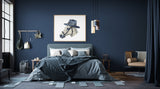 a bedroom with blue walls and a bed with a hat on it