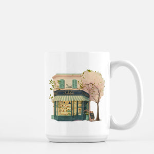 a coffee mug with a painting of a storefront