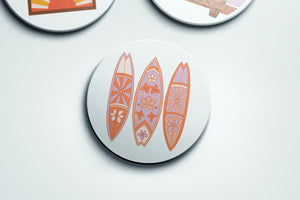 a group of three surfboards sitting on top of a white surface