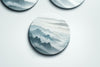 three round plates with mountains painted on them