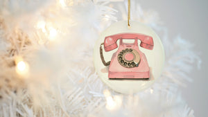 a pink phone ornament hanging from a christmas tree