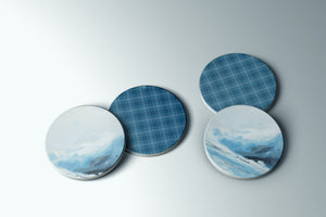 three plates with designs of mountains and clouds on them