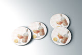 a collection of circular coasters with illustrations of cocktails and garnishes, such as lemon slices and bottles.