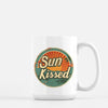 a white coffee mug with the words sun kissed on it