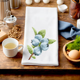 a wooden table topped with a cup of tea and a tea towel