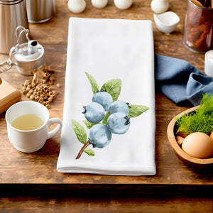 a wooden table topped with a cup of tea and a tea towel