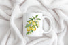 a coffee mug with a painting of lemons on it