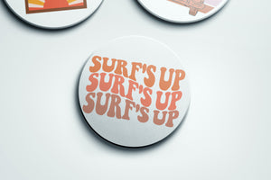 three buttons with different designs on them that say surf's up