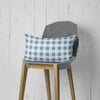 a blue and white checkered pillow sitting on top of a wooden chair