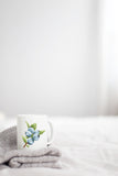 a white coffee mug with blue flowers on it