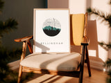 A framed print of a cityscape with a mountain range in the background is displayed on a wooden chair, with a yellow cushion on the chair.