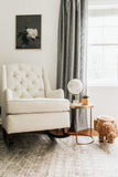 a living room with a white chair and a rug