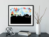 Auburn Alabama art print. Features the Auburn Alabama skyline and a geometric background. In blue and shown in a black frame. Other colors and frame options available. Designed by Paperfinch.