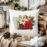 a white pillow with a picture of poinsettis and pine cones