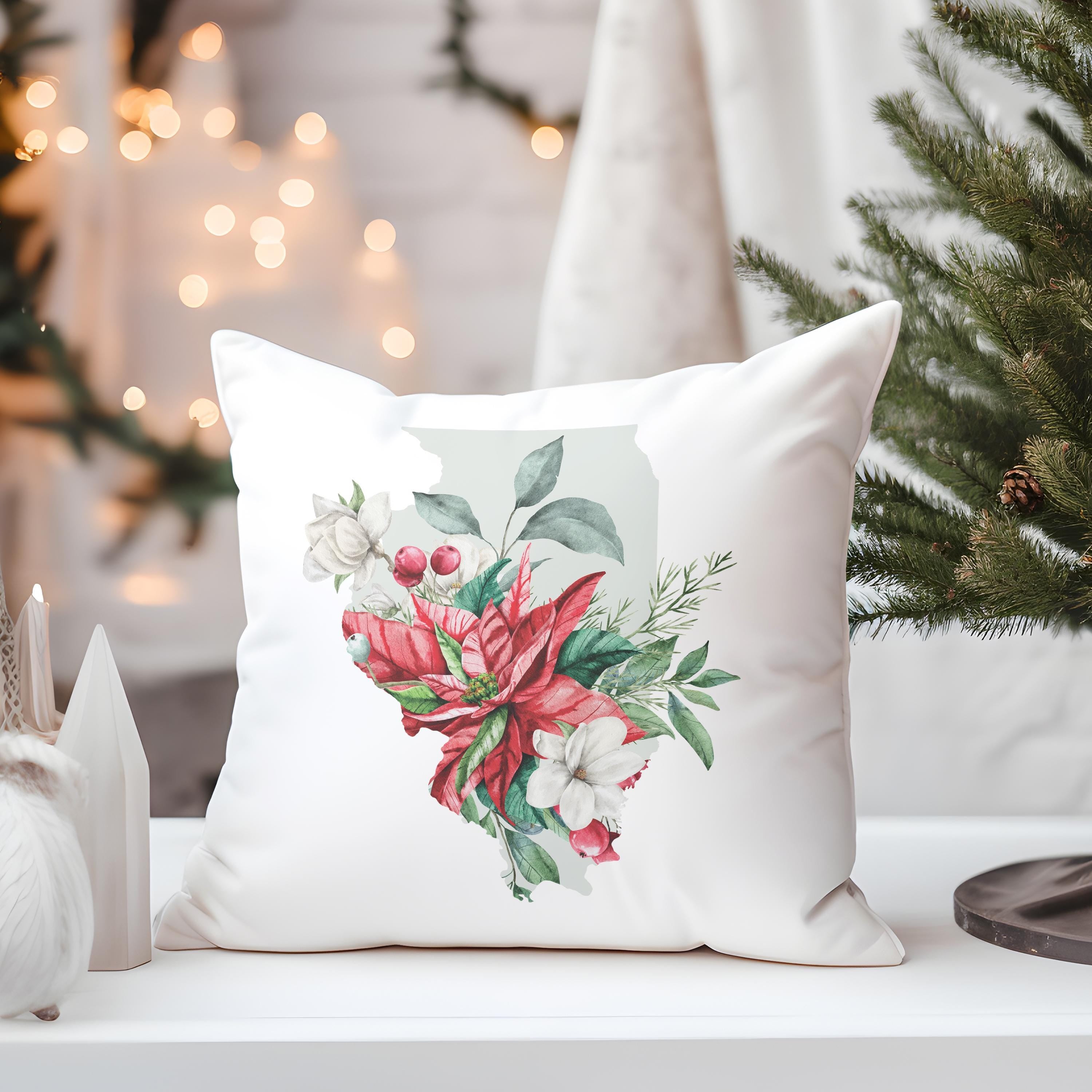 a white pillow sitting on top of a table next to a christmas tree