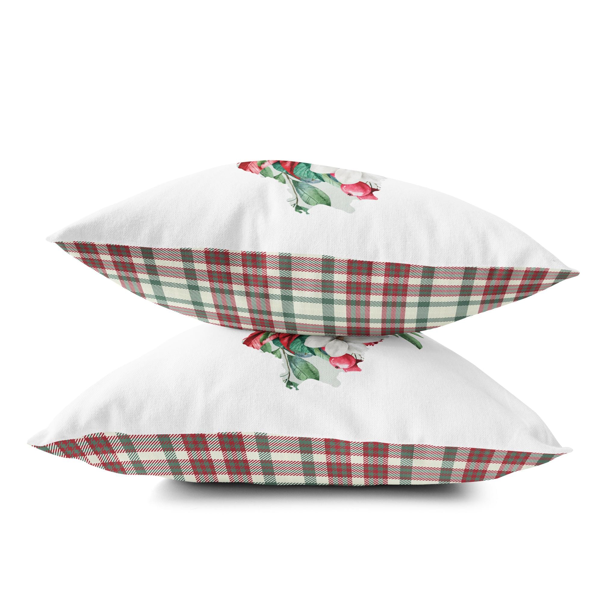 two white pillows with red and green flowers on them